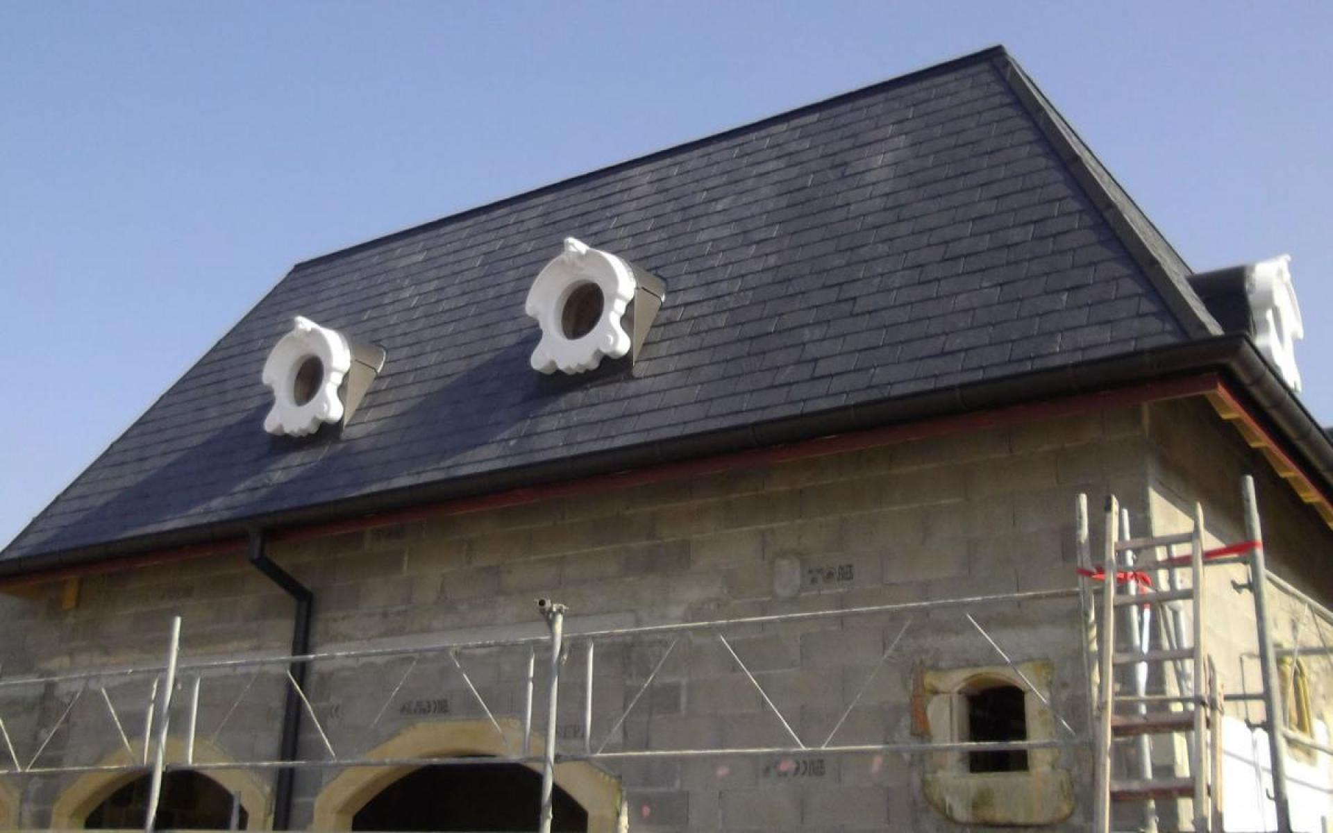 Toiture en ardoise avec des lucarnes sculptées